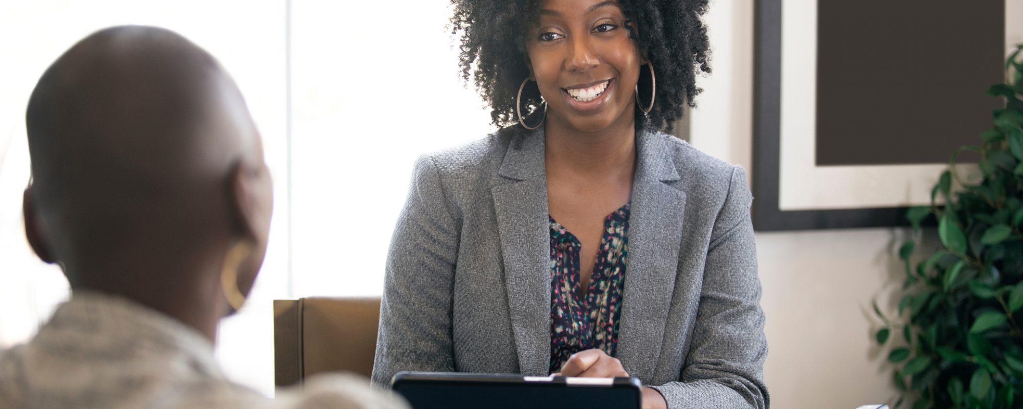 Black female businesswoman in an office with a client giving legal advice about taxes or financial loans. The woman could be a lawyer or a cpa accountant.; Shutterstock ID 1344795773; Purchase Order: comps; Job: ; Client/Licensee: ; Other: